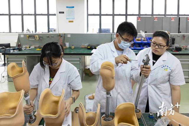 四月中旬，假肢技师钟正科在指导实习生郑佳彤进行假肢组装工作。
